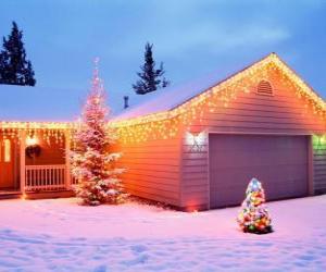 Puzle Dům zdobené vánoční ozdoby a dva vánoční stromy v zahradě