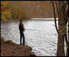 Rybolov - Rybář na řece akci v lesnaté krajině