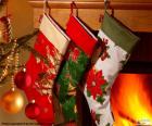 Ponožky s vánoční výzdobou a visí na zdi komína