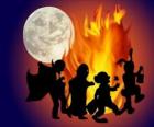 kostýmované děti tančí kolem ohně