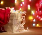 Vánoční dárek zabalený v bílém papíře a zdobené s lukem