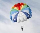Parašutista dolů skrz mraky ve padák po skoku z letadla
