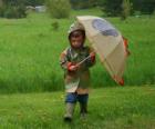 Boy s jeho deštníkem a pláštěnka v rámci jarní déšť