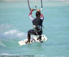 Kitesurfing je extrémní sport, klouzání po vodě, v níž vítr pohání kite