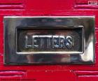 Poštovní schránka na červených dveřích