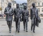 Socha Beatles v Liverpoolu. Britská rocková a popová skupina, nejobdivovanější a nejoblíbenější ze šedesátých let a jedna z nejvlivnějších v historii hudby. Tvoří John Lennon, Paul McCartney, George Harrison a Ringo Starr